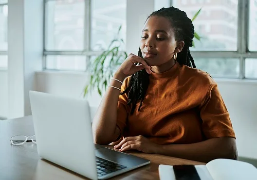 Young professional looking at her loan options on her laptop